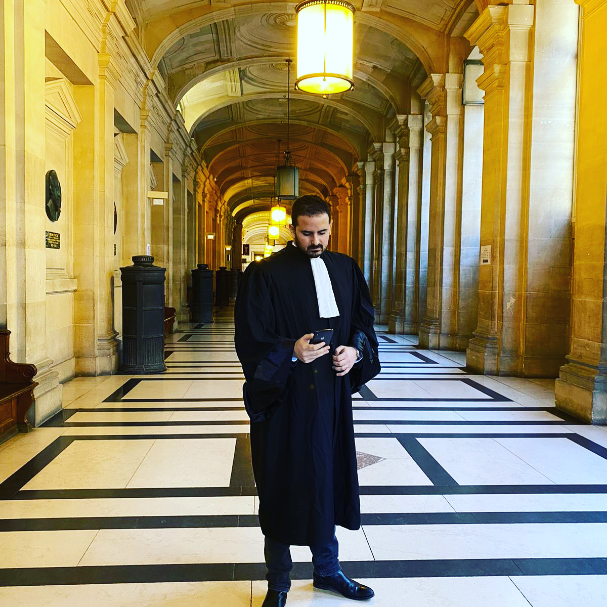 Avocat pénaliste dans son cabinet parisien moderne, examinant des dossiers de cas sur son bureau